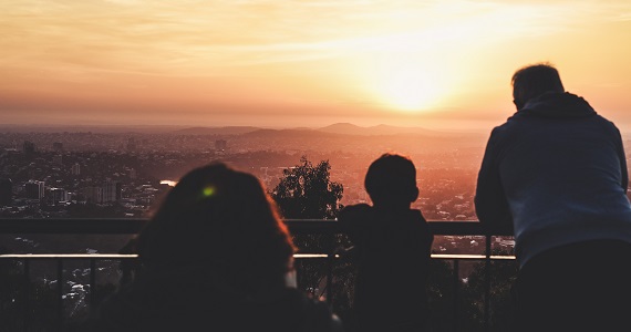family overlooking city at sunset